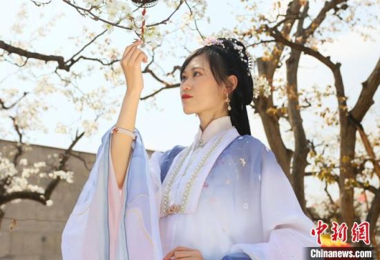 圖為蘭州青年身穿漢服在百年梨園賞景?！「哒?攝