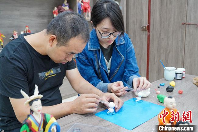 <a target='_blank'  data-cke-saved- >中新社</a>記者(右)現(xiàn)場(chǎng)體驗(yàn)面塑制作過程?！￡悹?zhēng)強(qiáng) 攝
