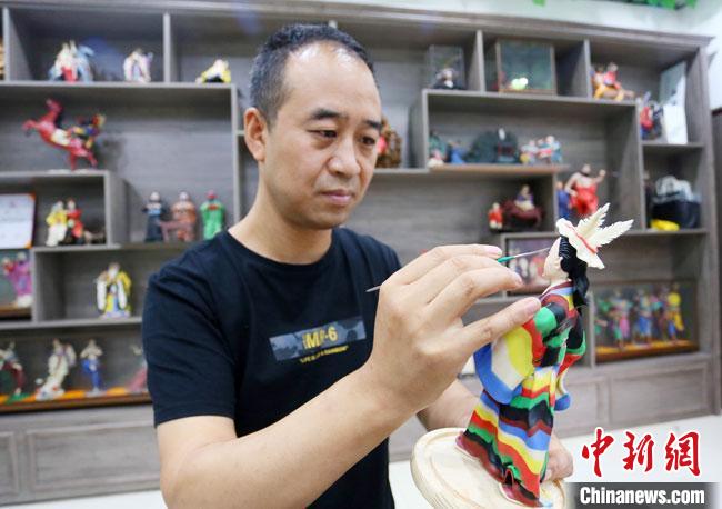 圖為安秋平正在創(chuàng)作代表隴南文縣民俗的《白馬人》作品?！「哒?攝