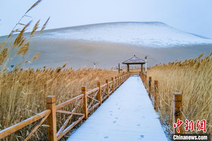 2021年11月28日，在敦煌鳴沙山月牙泉景區(qū)，沙雪交融，更顯北國(guó)風(fēng)情?！⊥醣筱y 攝