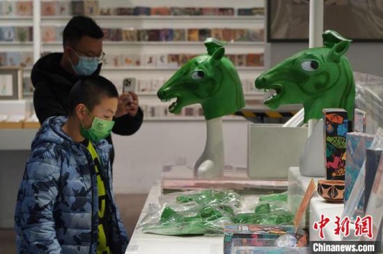 圖為“神馬來了”銅奔馬頭套吸引參觀者駐足?！【琶赖┰?攝