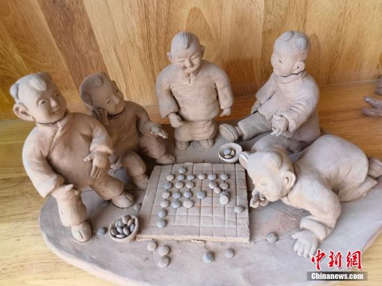 圖為泥塑作品展現(xiàn)下棋場(chǎng)景。 劉玉桃 攝