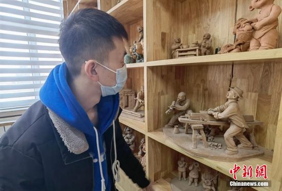 圖為學(xué)生欣賞泥塑作品。 劉玉桃 攝