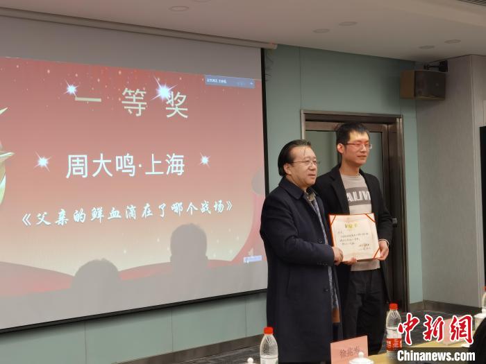 圖為作家、西北師范大學(xué)新聞與傳媒學(xué)院院長徐兆壽頒發(fā)一等獎(jiǎng)證書，代領(lǐng)獎(jiǎng)?wù)呱吓_(tái)領(lǐng)獎(jiǎng)。　楊娜 攝