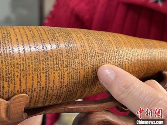 圖為長約二十公分的長條葫蘆雕刻佛教經(jīng)文作品?！堟?攝