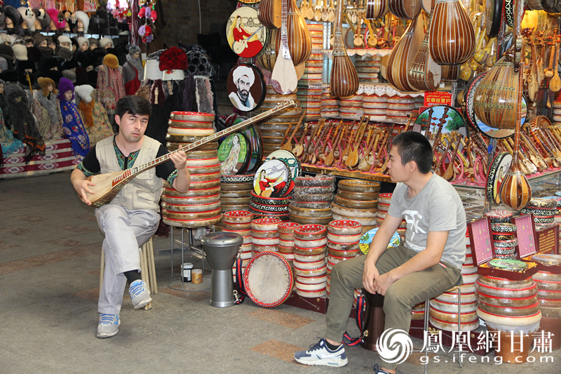 烏魯木齊二道橋巴扎內(nèi)，店主正在向客人展示樂器。楊文遠(yuǎn) 攝
