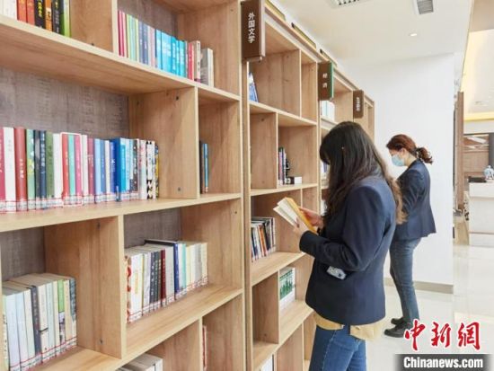 圖為在甘肅公航旅建設(shè)集團(tuán)有限公司的職工書屋，職工挑選書籍?！⌒煅?攝