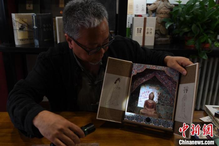 圖為讀者出版集團讀者晉林工作室獨立出品人徐晉林，展示互動性強的敦煌題材手工書。(資料圖) 楊艷敏 攝