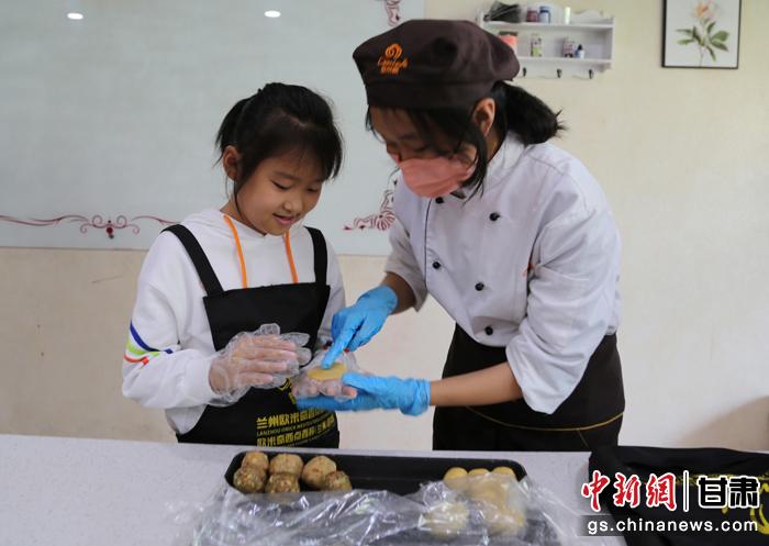 圖為在甘臺胞小朋友在工作人員指導下制作月餅。九美旦增 攝