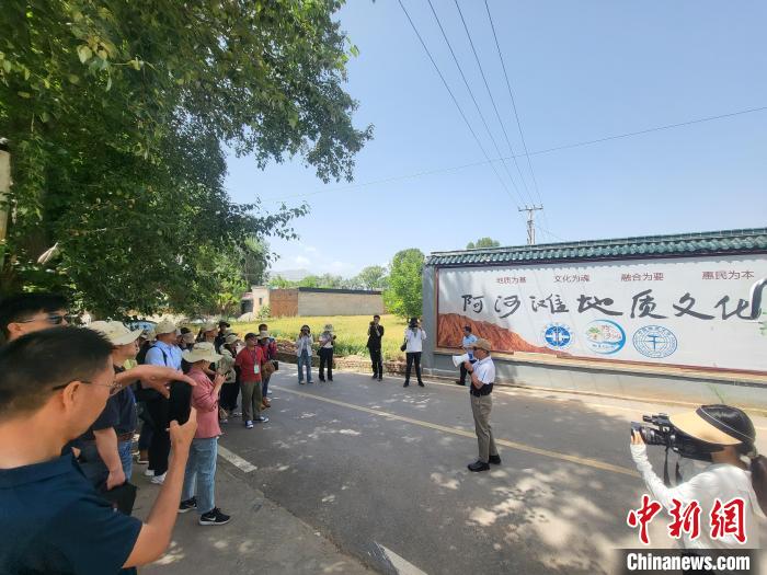 圖為中國地質(zhì)大學(xué)(北京)教授張緒教介紹村落情況?！『衍?攝