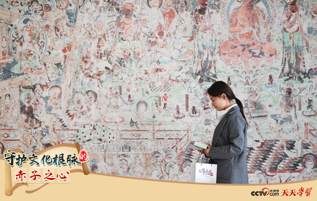 2023年4月25日，敦煌研究院文物數(shù)字化保護(hù)團(tuán)隊(duì)創(chuàng)意營(yíng)銷人員廖雪婷從一幅高保真復(fù)制壁畫(huà)前走過(guò)。
