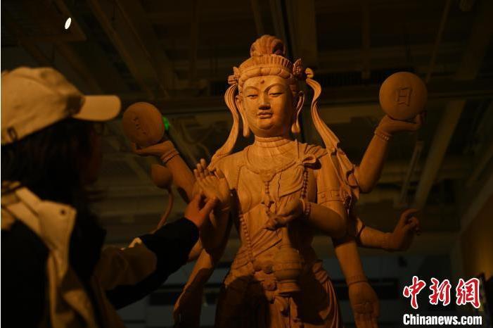 圖為季茂杰觀察自己創(chuàng)作的敦煌木雕。李亞龍 攝</p>
<p>