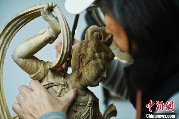 圖為季茂杰進(jìn)行敦煌元素的木雕創(chuàng)作。李亞龍 攝</p>
<p>