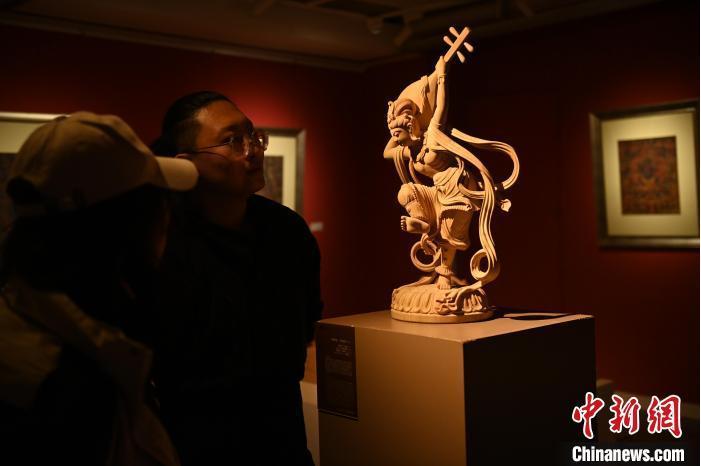 圖為季茂杰向參觀者介紹自己創(chuàng)作敦煌木雕的過程。李亞龍 攝</p>
<p>