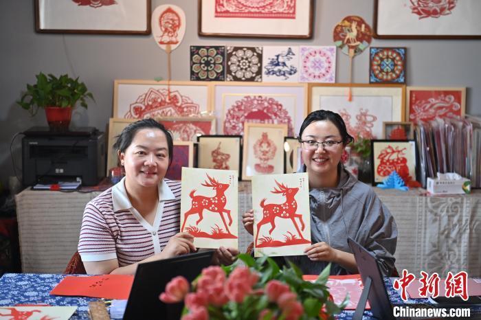 6月6日，在甘肅敦煌青年夜校課程中，青年學(xué)員展示學(xué)習(xí)敦煌非遺剪紙的成果。李亞龍 攝　　