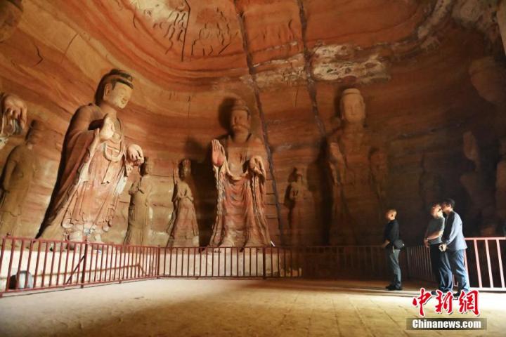 7月15日，游人參觀甘肅省平?jīng)鍪袥艽h百里石窟長(zhǎng)廊中的南石窟寺1號(hào)窟。百里石窟長(zhǎng)廊位于涇川縣境內(nèi)，由512個(gè)石窟、5眼窟中石井組成，現(xiàn)存王母宮石窟、鳳凰山石窟、南石窟寺、丈八寺石窟、羅漢洞石窟、太山寺石窟等規(guī)模較大的石窟群，還有數(shù)量眾多的小石窟群。南石窟寺開鑿于北魏永平三年，其中1號(hào)窟屬于大型七佛窟，七佛高達(dá)6米。中新社記者 李亞龍 攝