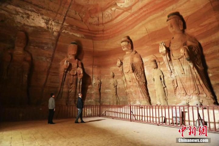 7月15日，游人參觀甘肅省平?jīng)鍪袥艽h百里石窟長(zhǎng)廊中的南石窟寺1號(hào)窟。百里石窟長(zhǎng)廊位于涇川縣境內(nèi)，由512個(gè)石窟、5眼窟中石井組成，現(xiàn)存王母宮石窟、鳳凰山石窟、南石窟寺、丈八寺石窟、羅漢洞石窟、太山寺石窟等規(guī)模較大的石窟群，還有數(shù)量眾多的小石窟群。南石窟寺開鑿于北魏永平三年，其中1號(hào)窟屬于大型七佛窟，七佛高達(dá)6米。中新社記者 李亞龍 攝
