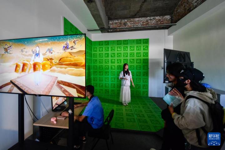 7月22日，游客體驗(yàn)“尋境敦煌——數(shù)字敦煌沉浸展”后，在虛擬演播廳拍攝一段真人與洞窟虛擬場(chǎng)景交互的視頻。新華社記者 郎兵兵 攝</p>
<p>